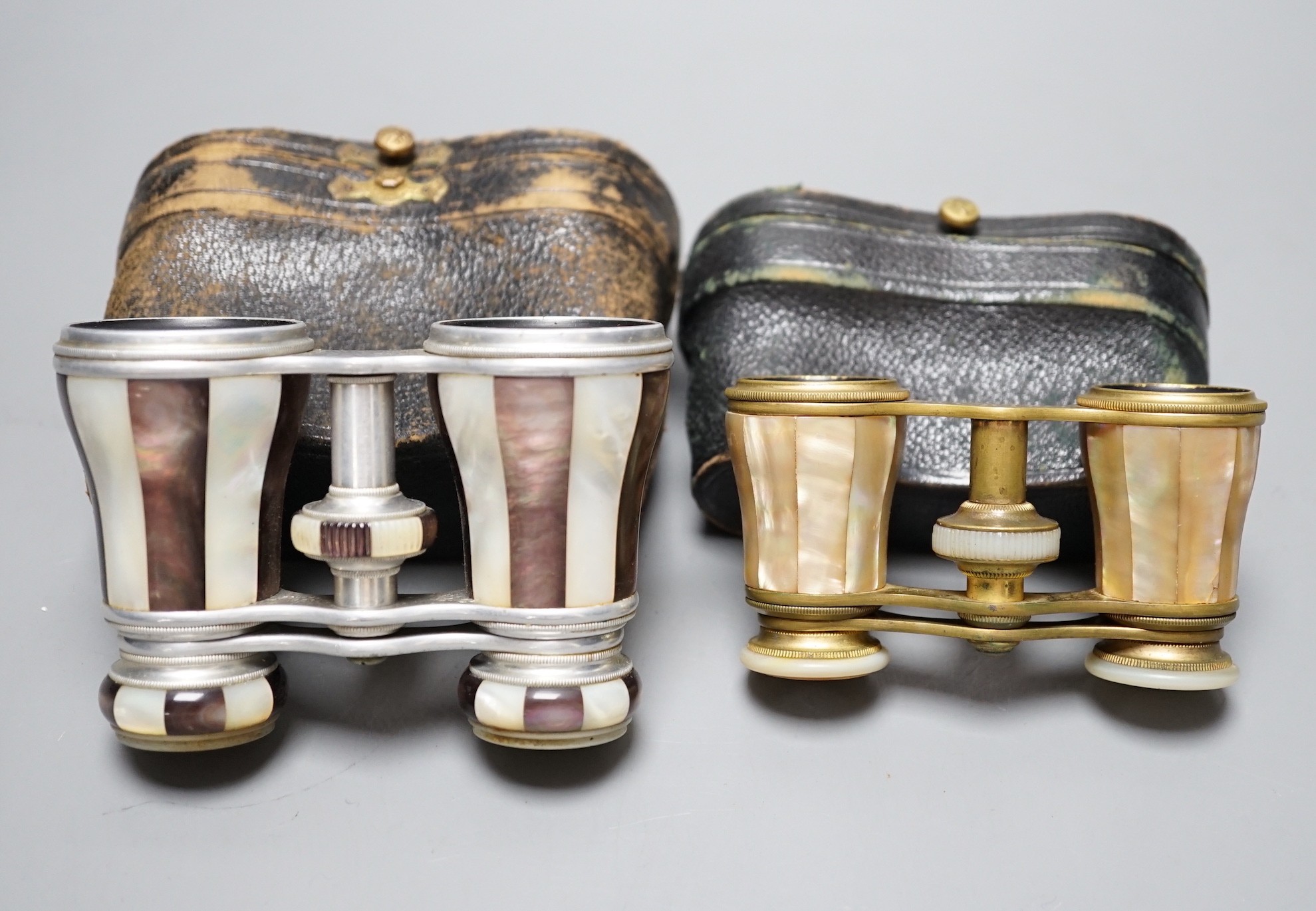 Two pairs of mother of pearl opera glasses; one marked Lemaire Fab, Paris to one lens and F.G. Schmidt, New York to the other, and Marghand Paris to the smaller pair